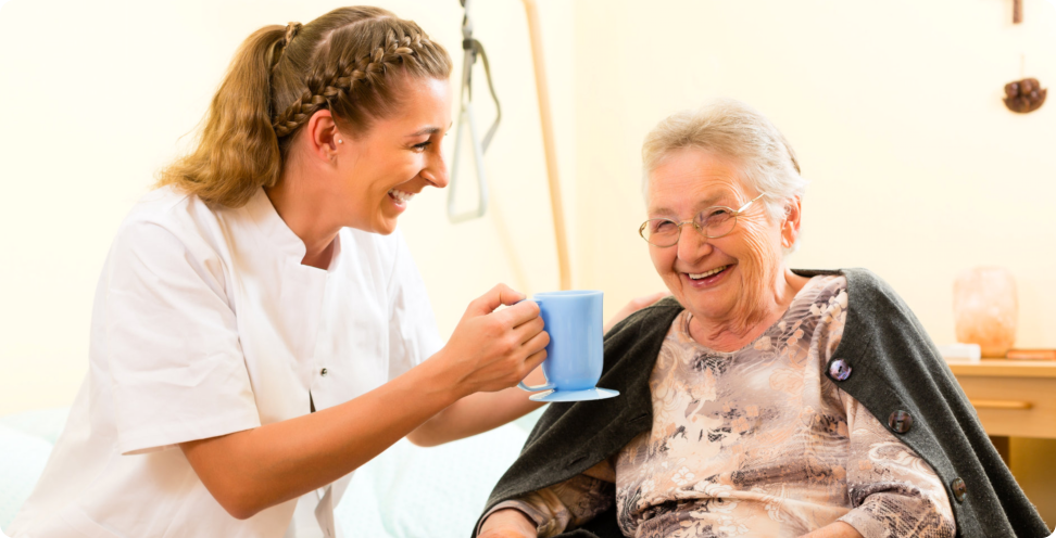 caregiver assisting her patient in drinking